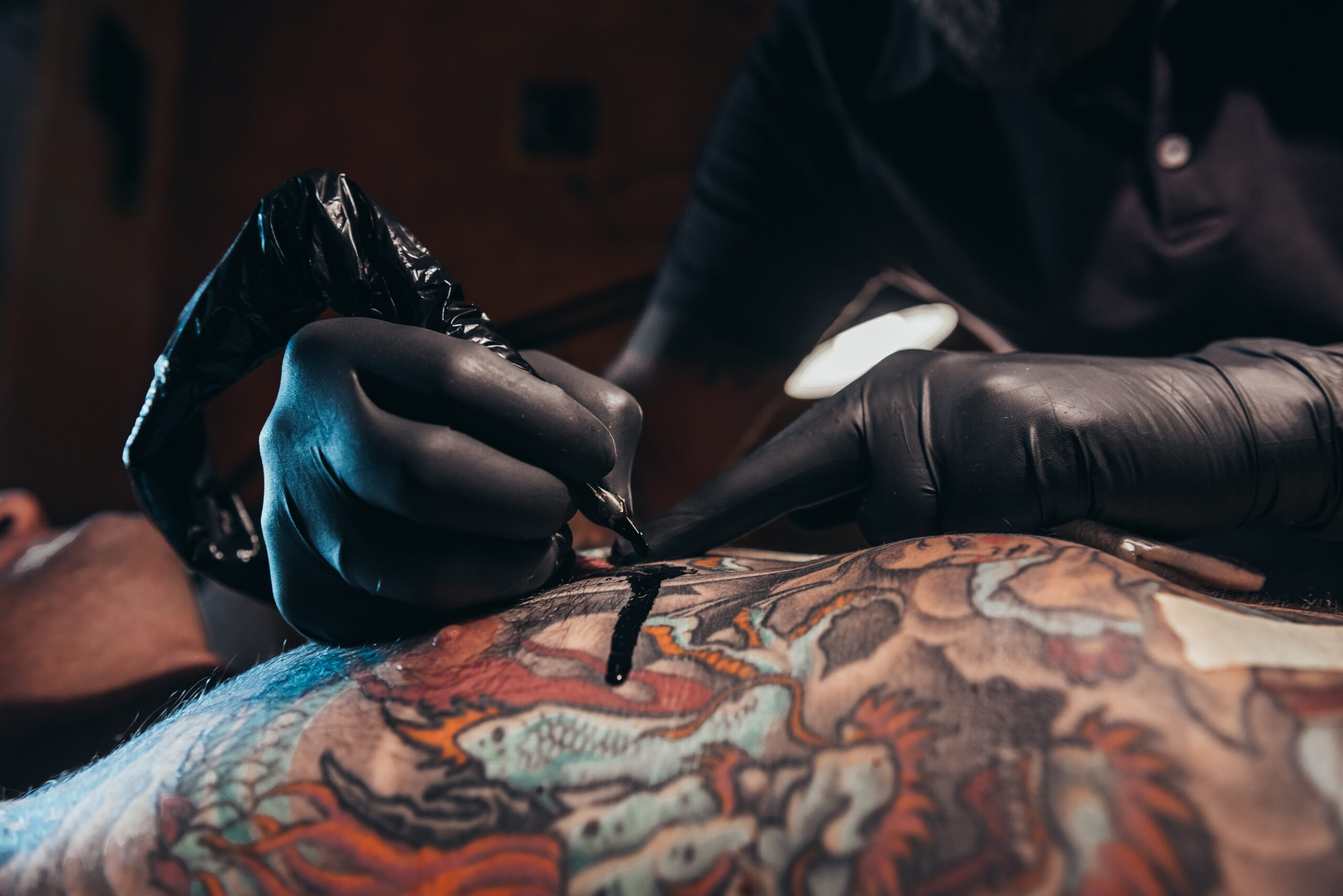 Shot,Of,A,Tattoo,Artist,Hands,Coloring,Tattoo,On,Men
